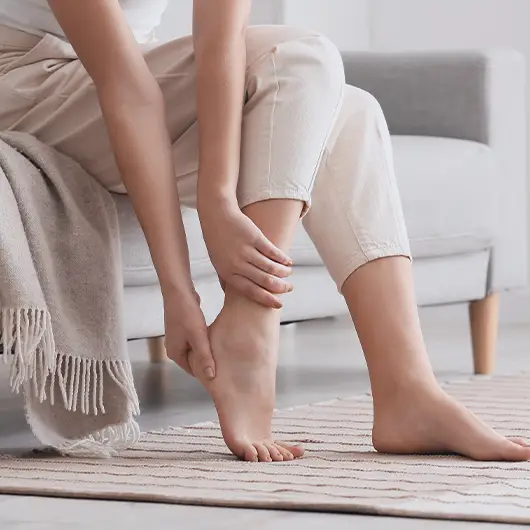 Woman on couch with foot and ankle pain