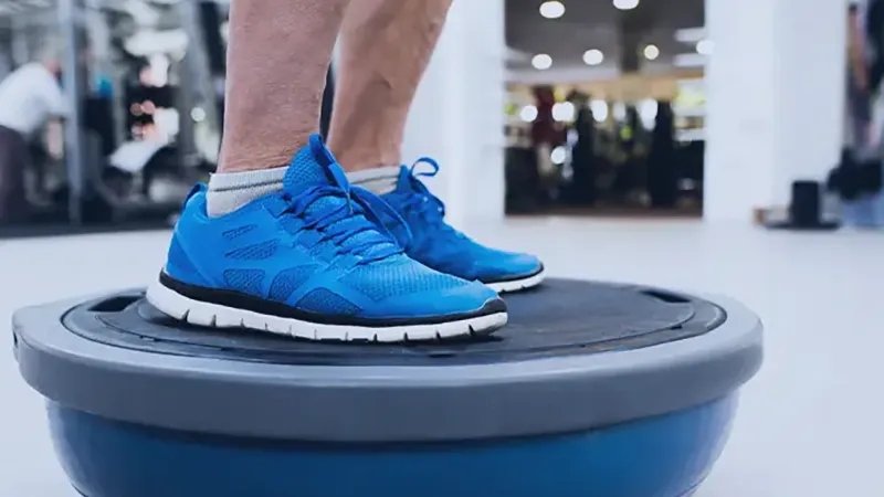 Senior man doing physical therapy on balance ball